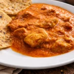 Masleni piščanec postrežen z naan kruhom